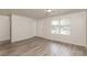 Bright living room featuring gray vinyl flooring and a large window at 1203 Sandune Dr, Norcross, GA 30093