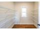 Walk-in closet featuring hardwood flooring, a window, and wire shelving for optimal storage at 1330 Temple Draketown Rd, Temple, GA 30179