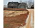 Gray farmhouse exterior with gravel driveway and unfinished landscaping at 1330 Temple Draketown Rd, Temple, GA 30179