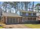 Inviting home featuring a charming front porch, a two-car garage, and mature trees at 201 Nouveau Sw Ct, Lilburn, GA 30047