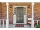 Inviting entrance with white columns, a dark front door, and decorative sidelights at 201 Nouveau Sw Ct, Lilburn, GA 30047