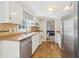 Well-lit kitchen with stainless steel dishwasher, white cabinetry, and tile backsplash at 201 Nouveau Sw Ct, Lilburn, GA 30047