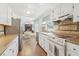 Well-lit kitchen offering stainless steel appliances and an open view to the eat-in kitchen and living room at 201 Nouveau Sw Ct, Lilburn, GA 30047