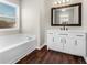 Modern bathroom with white vanity, dark floors, and a bathtub at 11602 Kades Trl, Hampton, GA 30228