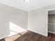 Sunlit bedroom with dark brown wood floors and access to hallway at 11602 Kades Trl, Hampton, GA 30228