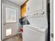 Laundry room with stacked washer and dryer, overhead cabinet, and door to the outside with pet door at 1349 Highway 81 E, Mcdonough, GA 30252