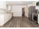 Kitchen boasts white cabinets, stainless steel appliances, and wood-look floors at 1853 Edington Sw Rd, Marietta, GA 30064