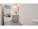 Modern powder room featuring gray vanity with quartz countertop and matte black hardware at 4322 Timberland Sw Dr, Lilburn, GA 30047