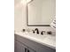 Stylish powder room features granite counters, trendy faucet and fixtures, and a black framed mirror at 4322 Timberland Sw Dr, Lilburn, GA 30047