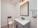 Elegant half bath with a modern vanity, stylish mirror, and a neutral color palette at 4322 Timberland Sw Dr, Lilburn, GA 30047