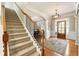 Elegant entryway with hardwood floors, a chandelier, and a wooden staircase at 4955 Heathcliff Way, Cumming, GA 30041