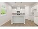 Modern kitchen with island, white cabinets, and granite countertops at 7083 Brushwood Bend (Lot 52), Lithonia, GA 30058