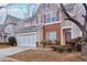 Two-story house with a brick and siding exterior, three-car garage, and landscaping at 3335 Briaroak Dr, Duluth, GA 30096