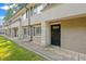 Tan brick building exterior with black doors and green lawn at 6940 Roswell Rd # 24E, Sandy Springs, GA 30328