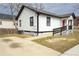 Charming bungalow-style home with white siding, black trim, a red door and a convenient access ramp at 967 Metropolitan Sw Pkwy, Atlanta, GA 30310