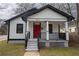 Charming renovated home featuring a bright red front door, covered porch, and fresh, modern paint at 967 Metropolitan Sw Pkwy, Atlanta, GA 30310