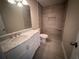 Bathroom with white vanity, marble countertop, and tile shower at 1168 Dogwood Nw Ct, Conyers, GA 30012