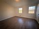 Bright bedroom with dark brown wood-look flooring and two windows at 1168 Dogwood Nw Ct, Conyers, GA 30012