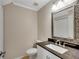 Stylish powder room with an ornate mirror, modern vanity, and contemporary fixtures enhancing the elegant design at 1094 Old Roswell Rd, Roswell, GA 30076