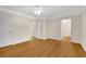 Bright bedroom featuring hardwood floors, neutral walls, ceiling fan, and multiple access doors at 1094 Old Roswell Rd, Roswell, GA 30076