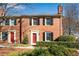 Charming brick townhouse with red door, black shutters, and well-manicured landscaping at 1094 Old Roswell Rd, Roswell, GA 30076