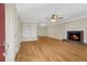 Inviting living room featuring a cozy fireplace, ceiling fan, and light wood flooring at 1094 Old Roswell Rd, Roswell, GA 30076