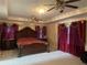 Spacious Primary bedroom with ornate bed and ceiling fan at 240 Flowers Cove Ln, Lilburn, GA 30047