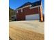 Brick house with a white garage door and a screened porch at 240 Flowers Cove Ln, Lilburn, GA 30047