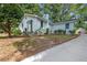 Charming white house with green door, landscaping, and a long driveway at 1315 Mcclelland Sw Ave, East Point, GA 30344