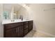 Double vanity bathroom with dark wood cabinets and a large mirror at 286 Staley Drive, Tucker, GA 30084