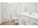 Bathroom features a shower with sliding glass doors, white cabinets, and laminate floors at 7293 Eton Ln, Locust Grove, GA 30248