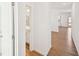 Bright hallway with hardwood floors leading to a bathroom, kitchen, and living area at 7293 Eton Ln, Locust Grove, GA 30248