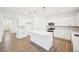 New kitchen boasting white cabinets, modern appliances, and a center island, adjacent to the entryway at 7293 Eton Ln, Locust Grove, GA 30248