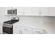 Kitchen detail with gray backsplash, stainless steel appliances, and white countertops at 7293 Eton Ln, Locust Grove, GA 30248