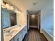 Main bathroom with double sink vanity, bathtub, shower and hardwood floors at 7293 Eton Ln, Locust Grove, GA 30248