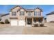 Brick two-story house with a three-car garage and landscaping at 7705 Sylvaner Ln, Atlanta, GA 30349