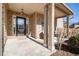 Covered front porch with brick columns and entry door at 7705 Sylvaner Ln, Atlanta, GA 30349