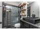 Modern bathroom with dark tile shower, floating shelves and black vanity at 201 Edwards Brook Ct, Canton, GA 30115