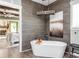 Relaxing bathroom with a freestanding soaking tub and wood-like wall tiles at 201 Edwards Brook Ct, Canton, GA 30115