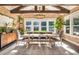 Bright dining room with a large farmhouse table, exposed beams, and brick accent wall at 201 Edwards Brook Ct, Canton, GA 30115