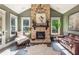 Bright living room featuring a stone fireplace and large windows offering abundant natural light at 201 Edwards Brook Ct, Canton, GA 30115