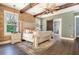 Spacious main bedroom with a large bed, exposed beams, and sliding barn door to en-suite bath at 201 Edwards Brook Ct, Canton, GA 30115