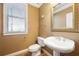 Powder room with pedestal sink, toilet, and decorative mirror at 6820 Milbury Ct, Alpharetta, GA 30005