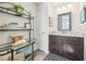 Bathroom featuring dark vanity, shelves, decorative pillows, and a framed mirror at 2090 Red Barn Ct, Cumming, GA 30040