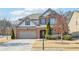 Charming two-story home with brick and siding exterior, attached garage, and manicured lawn at 2090 Red Barn Ct, Cumming, GA 30040