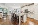 Open kitchen boasts a center island with bar seating, granite countertops, stainless appliances, and hardwood floors at 2090 Red Barn Ct, Cumming, GA 30040