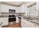 Modern kitchen with white cabinets, granite counters, and stainless steel appliances at 4071 Williamsburg Dr, Atlanta, GA 30337