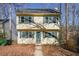 Two-story yellow house with green shutters and a charming front entrance at 1550 Park Creek Ne Ln, Brookhaven, GA 30319