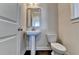 Small bathroom with pedestal sink and dark hardwood floors at 2329 Village Grove Dr, Suwanee, GA 30024