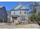 Two-story house with blue siding, brick accents, and a peach-colored door at 2329 Village Grove Dr, Suwanee, GA 30024